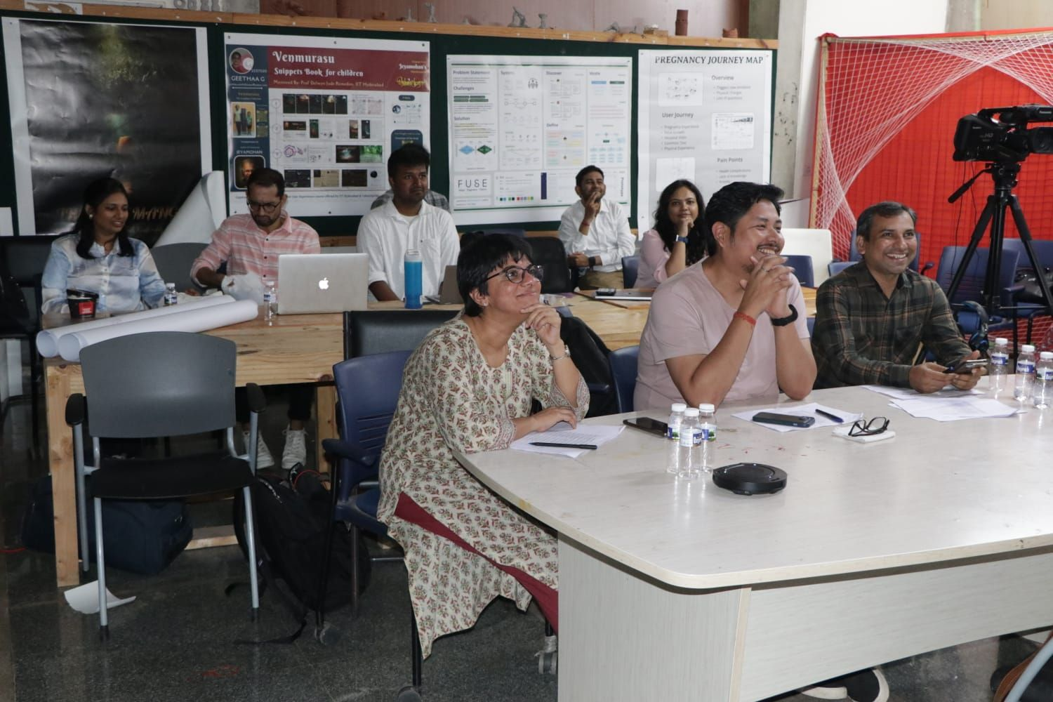 Design jury review with journey maps and posters on the walls